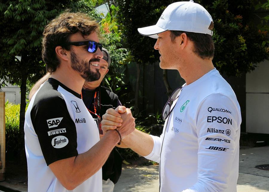 F1's tweet photo. WELCOME BACK! @nico_rosberg greets @alo_oficial after Alonso was passed fit to race at the #MalaysiaGP http://t.co/xHHlQMyVUK