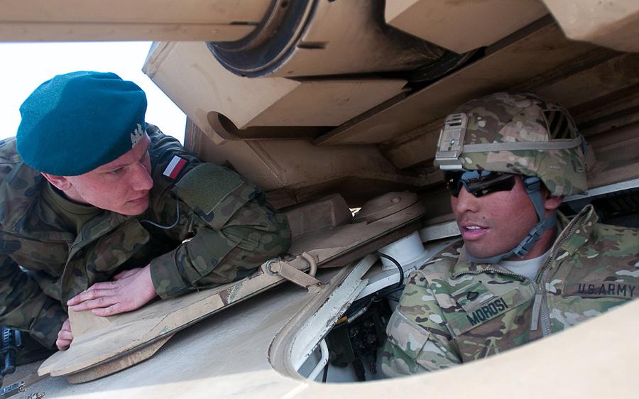 DefineStandard's tweet image. DRAWSKO POMORSKIE, Poland - Pfc. John Morosi, @3rd_Infantry, shows Polish army Pvt. Martin Mackowski an Abrams tank.