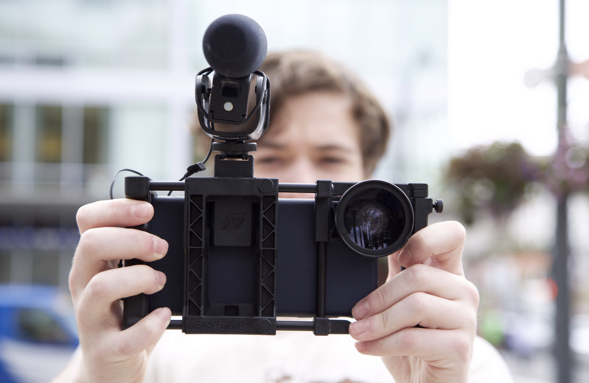 контент съемка. видеосъемка на телефон. снимаю видео сам. камера для блоггера. человек сидит перед камерой.