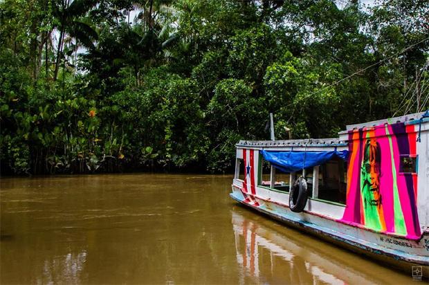 folha's tweet photo. Daltônico, artista pinta fachadas de casas e barcos em ilha no Pará  http://t.co/7h3PswrXsO http://t.co/BIAGtAIfzd