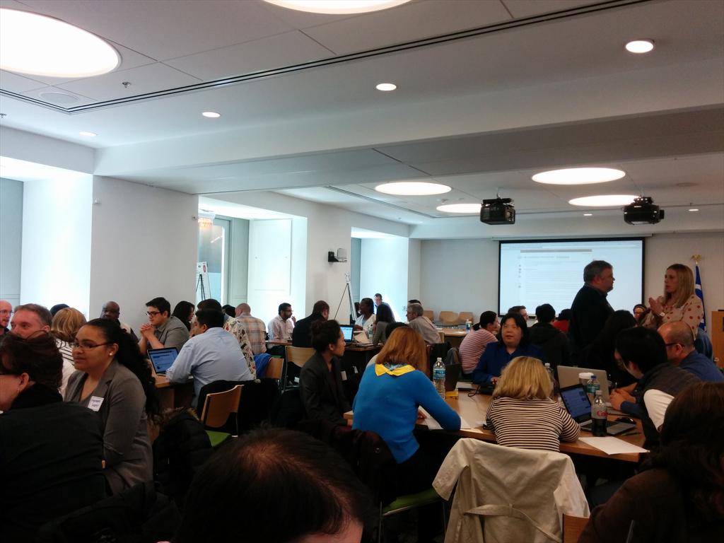 DGinzberg's tweet image. #a11yhack brain storming session going on. Pic in tweet: hackathon participants at tables discussing projects.