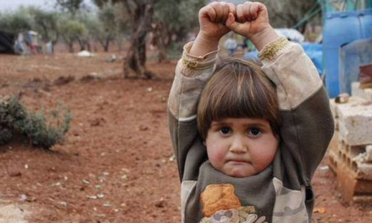 robertosaviano's tweet image. Quando difronte a un obiettivo una bimba alza le mani scambiandolo per canna del fucile nessuno può sentirsi assolto.