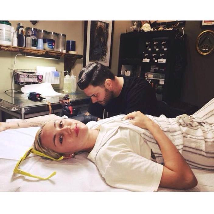 Smilerr23's tweet photo. Miley cuando se hacia su nuevo tatuaje "Biewty". http://t.co/F95OxYim1e