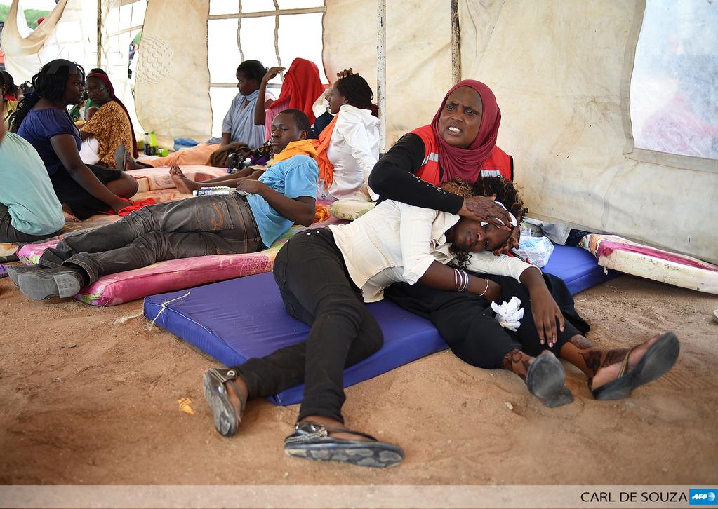 Una voluntaria de <a href="/KenyaRedCross/">Kenya Red Cross</a> atiende a estudiante en shock tras #GarissaAttack  <a href="/AFPphoto/">AFP Photo</a>