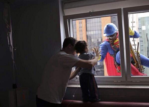 CoinWuTang's tweet photo. Un hombre vestido como Superman saluda a un niño, y a su padre en el Hospital Infantil Sabara en Sao Paulo, Brasil. http://t.co/LoxakuI93E