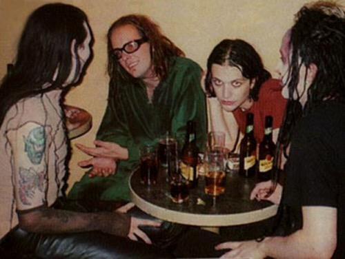 ppleating's tweet image. Brian Molko, Twiggy Ramirez and Marilyn Manson talking over drinks.