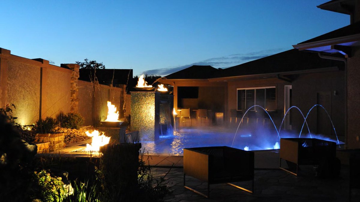Nightscape your outdoor living space with custom lighting, fire, and water features. midwestcustompools.com.