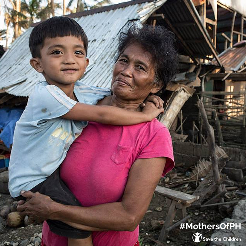 SaveChildrenPH's tweet photo. #MothersOfPH: Merlinda holds her son as she stands in front of their damaged home after #RubyH http://t.co/FvXrhyLF8D http://t.co/5spUTEaCIM