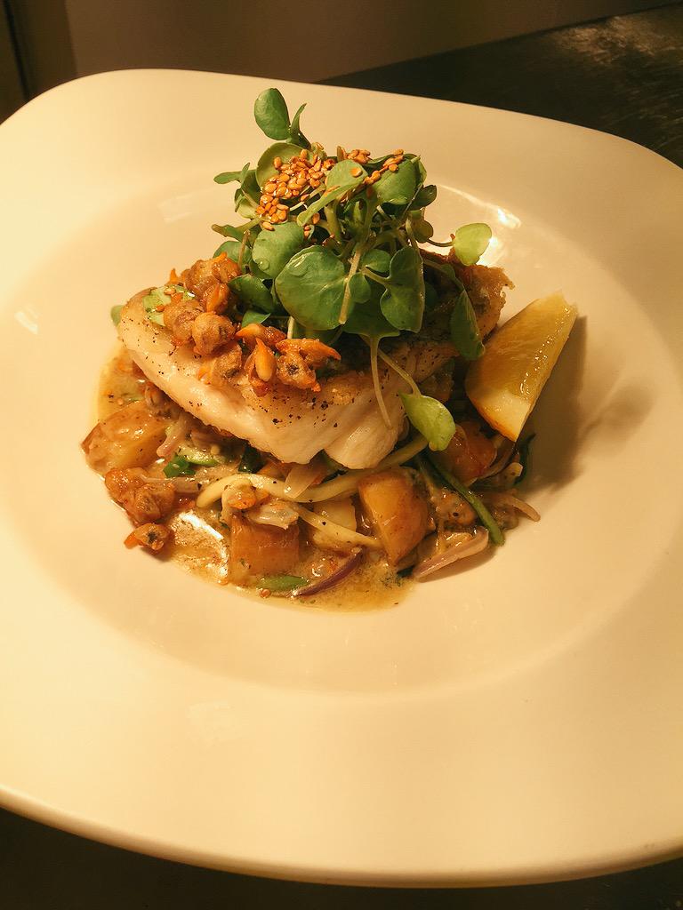Pan roasted hake with potato, coconut and courgette hash, toasted sesame and cockle 'popcorn'.