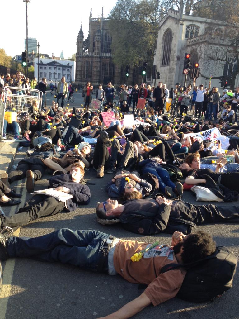 UKuncut's tweet photo. Beautiful direct action @LondonBlackRevs occupy the road with flowers outside parliament because #MigrantLivesMatter http://t.co/4F65H1wvoh
