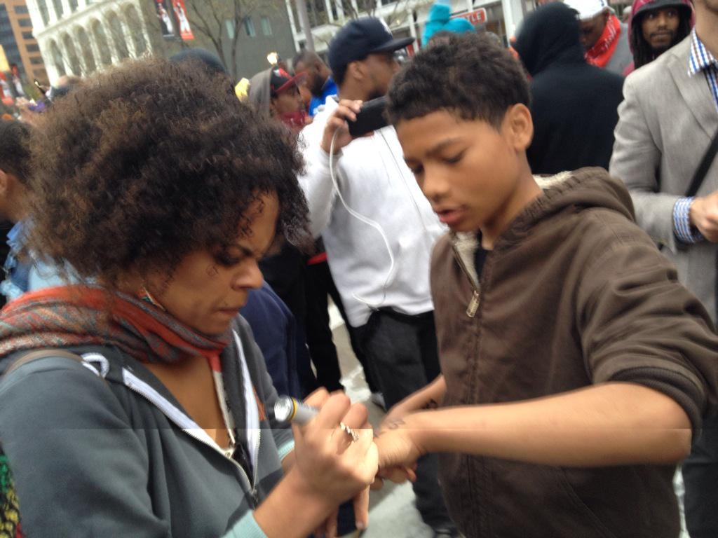kevrector's tweet photo. This woman is writing a number on kids' arms that she told them they can call in case they get arrested #FreddieGray http://t.co/tqXrx6gfb3