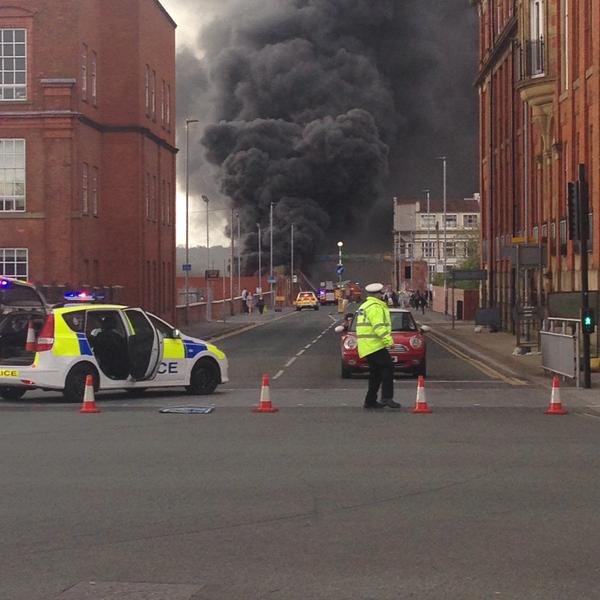 BBCNWT's tweet photo. Fire service say blaze in Salford producing huge column of thick black smoke is a tyre fire on Adelphi St. http://t.co/VXCy730oT5