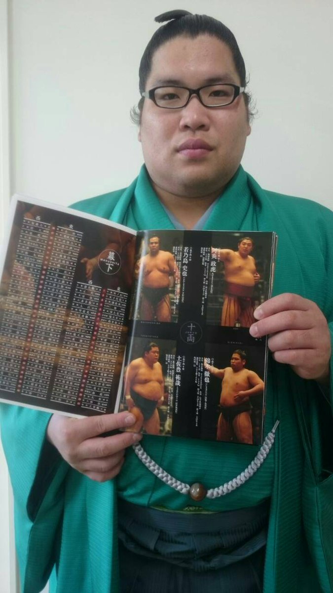 <力士会>本日は力士会が行われています。開始前、初参加の新十両錦木は緊張した面持ち。五月場所パンフレットの自分の登場ページを指してポーズ