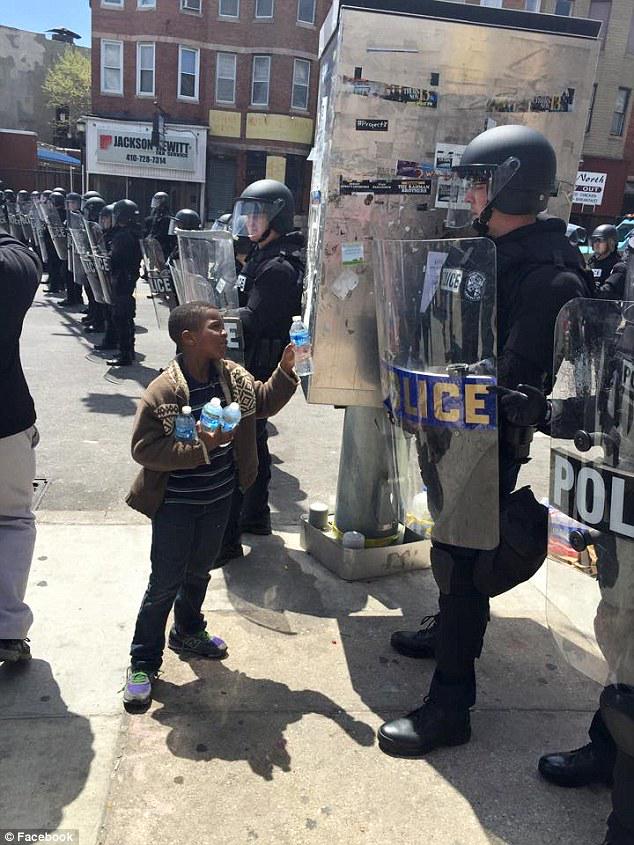 Daily_MailUS's tweet photo. Heroes of #BaltimoreRiots: Boy gives water to cops and man throws himself in front of rioters http://t.co/7D4tsLkc8I http://t.co/1ktMcpnTzz
