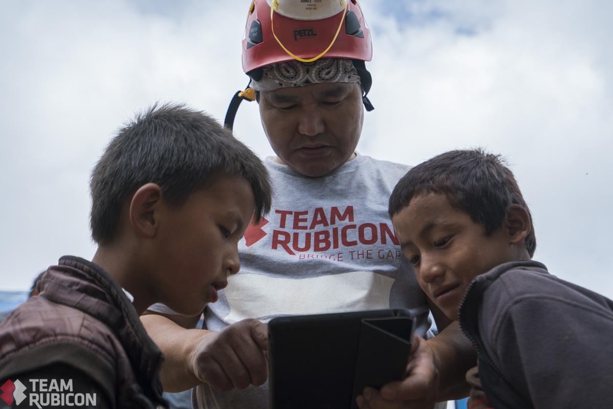 TeamRubicon's tweet photo. Students at the Yangrima Boarding School resumed class in a temporary shelter as our team cleared rubble nearby. http://t.co/dcxdM222UZ