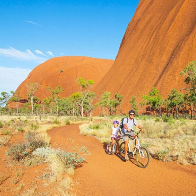 VisitCentralAus's tweet photo. Discover Uluru on the back of bike with the wind in your face with @MTB_TheAlice #RedCentreNT Photo by @ytravelblog http://t.co/3pVcWYy0Sm