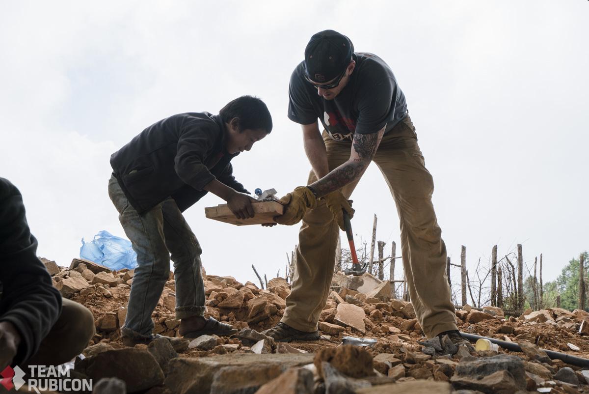 TeamRubicon's tweet photo. Firefighter and paramedic Joseph Brier hands off a salvaged science kit in the village of Sermathang, #Nepal. http://t.co/b6pzwOtcRU