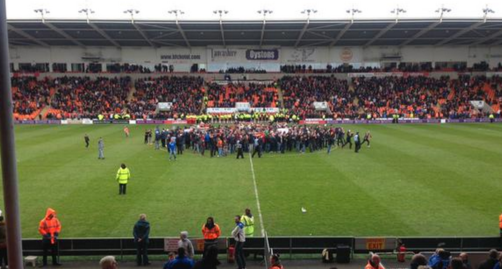 itvnews's tweet photo. Referee forced to take players off the pitch as fans invade pitch at Blackpool http://t.co/UVX1tFoegm http://t.co/w6r28IYXeF