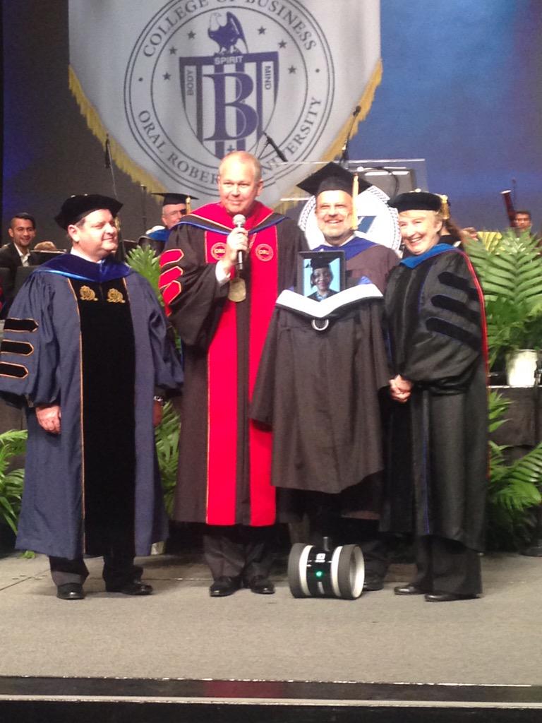 OralRobertsU's tweet photo. So proud to have one of our graduates "walk" the stage via Geo the Robot! #ORUGraduation #ORUGrad http://t.co/M7a0CnJr85