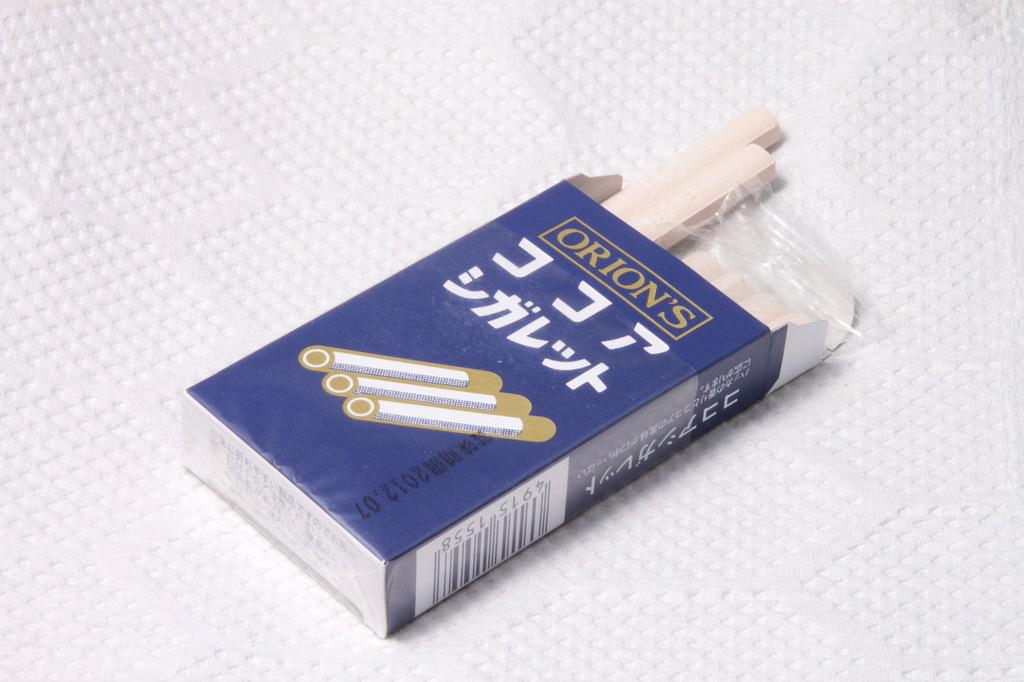 sidare_hotaru's tweet photo. オリオン（株）が1951年より販売し、長年親しまれ続けている…「ココアシガレット」よ！ 
たばこの箱を思わせるパッケージに砂糖とココアとハッカを原料にしたたばこ状のラムネ菓子が6本入っているわ。
#ほたるbot https://t.co/XLoqfJjGfy
