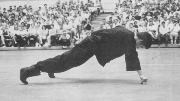 Bruce Lee doing a one hand push-up, using only an index finger and a thumb.