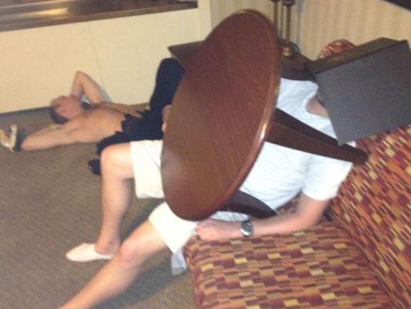 разломанная мебель в квартире. валяюсь под столом. разбил компьютер. человек сидит за столом спереди. человек на двух стульях.