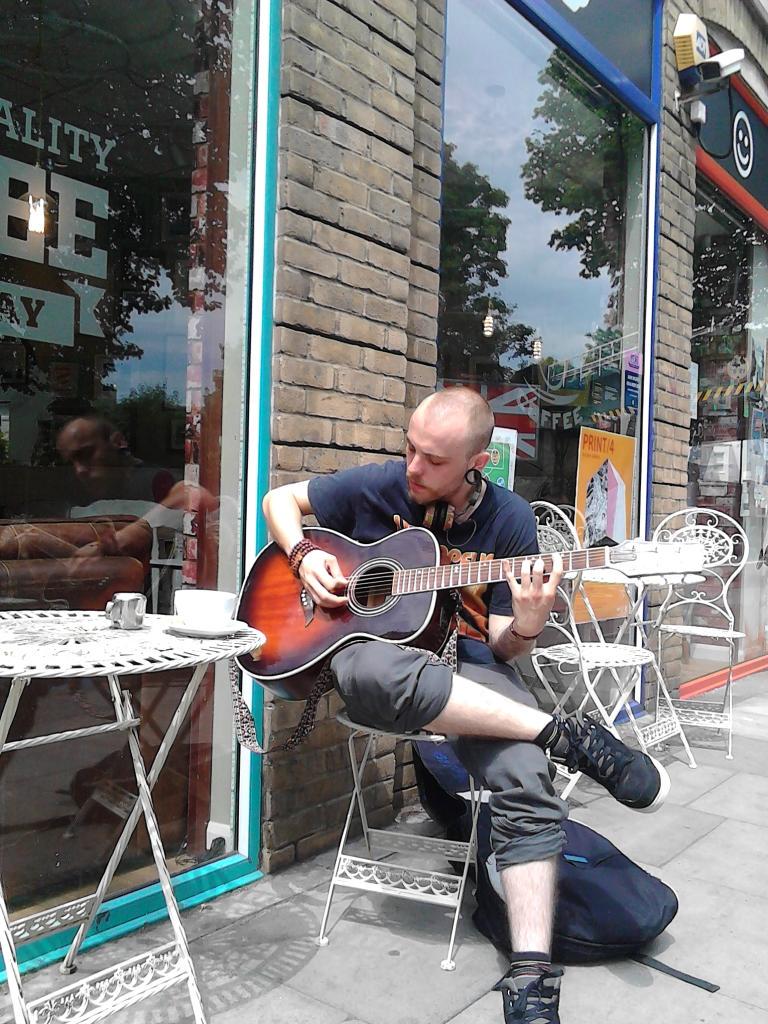 Ben <a href="/ThatOfTheDivine/">Ben Turner</a> making a bright day brighter playing outside our cafe while enjoying a cup of tea