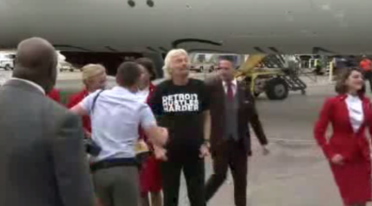 Local4News's tweet photo. PICS: @richardbranson steps off new #Detroit @VirginAtlantic flight wearing "Detroit Hustles Harder" shirt. http://t.co/bJpw3Tc5nM