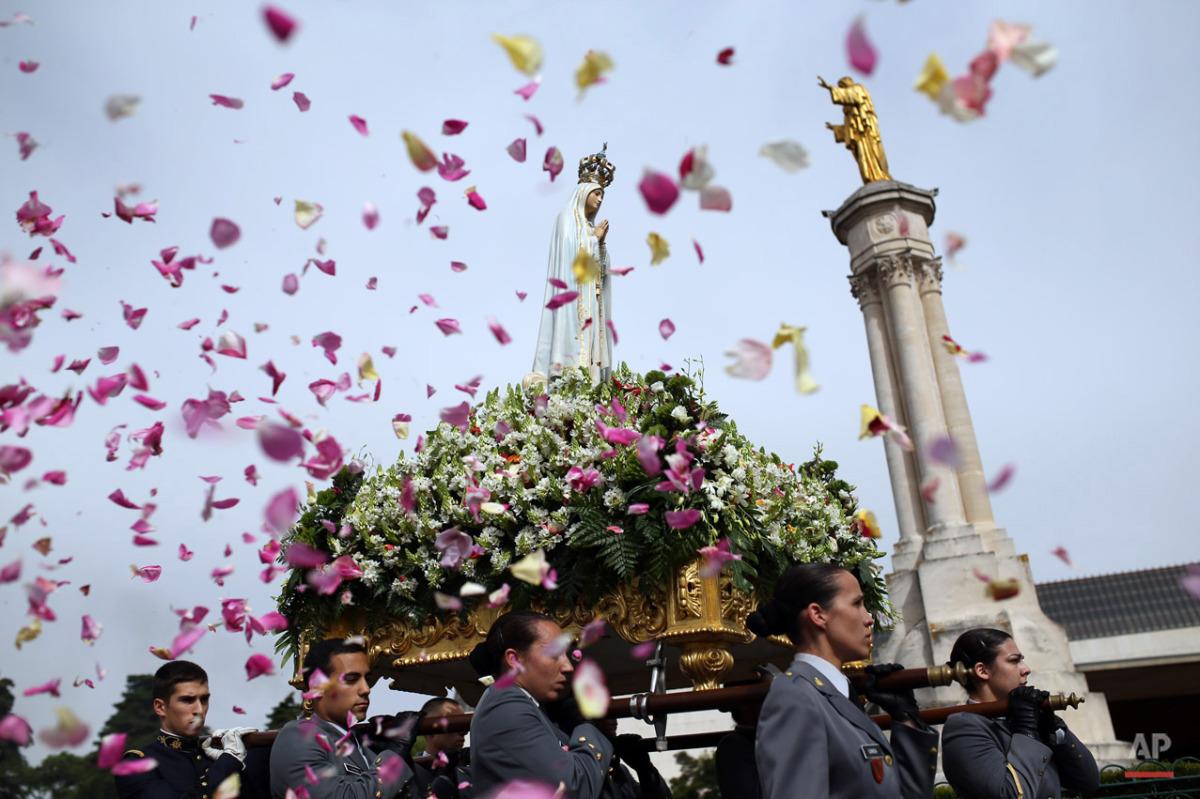nyip's tweet photo. Worshipers throw flower petals at the Our Lady of Fatima statue in this installment of @AP_Images #WorldInReview http://t.co/HIOV7YYrTf