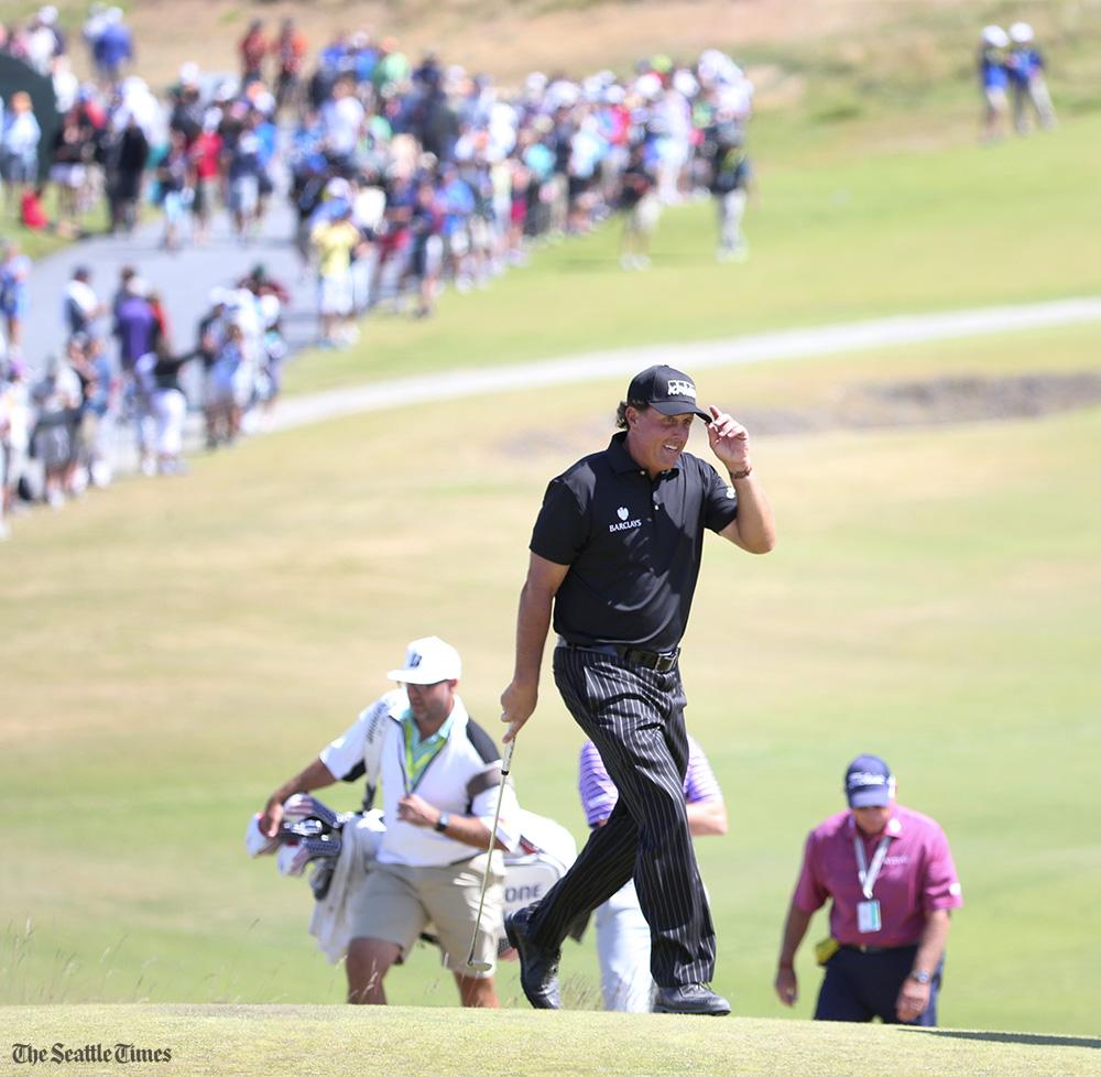 Phil Mickelson tips his hat to fans singing \"Happy Birthday\" to him as he approaches the ninth green 