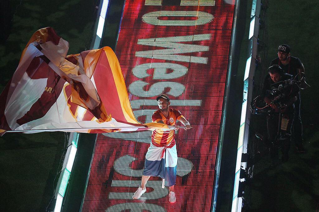 Sneijder is waving a massive Galatasaray flag at the club's title winning celebration. 