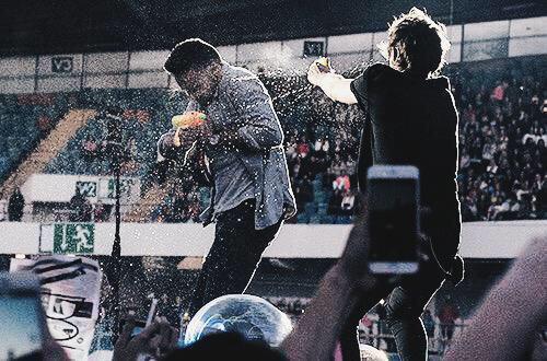 1DGlobalAlert's tweet photo. Louis throwing water at Liam on stage tonight in Helsinki. #OTRAFinland -N http://t.co/ly9ha4ypUp