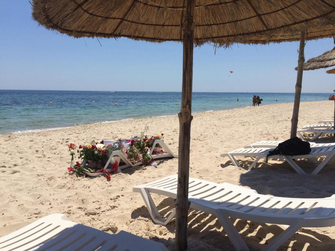 Beach where #Sousse attack took place reopened. A sunbed draped in flowers  marks the spot. And rows of empty chairs, image size:1076x807
