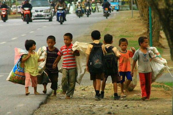 VIBRATlON's tweet photo. Two wealthy boys on their way to school passing a group of peers on their way to work in Indonesia. http://t.co/Q1rxMZT9E6