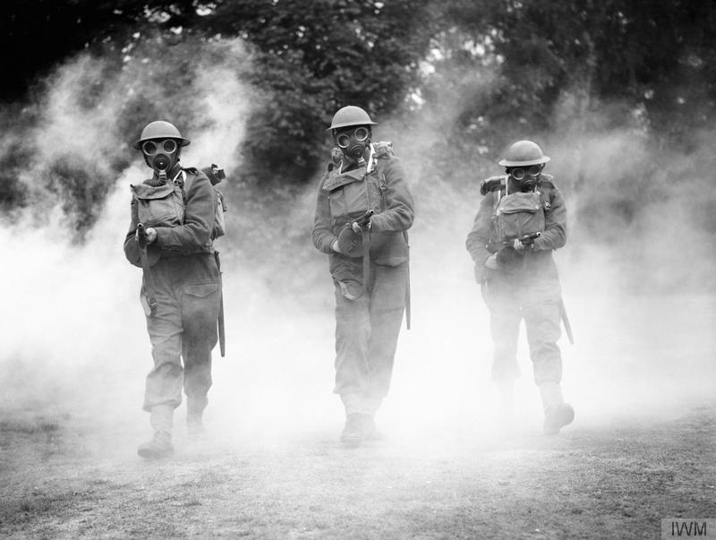 NotableHistory's tweet photo. Irish Guards wearing gasmasks advance through smoke with 'tommy guns' at the ready, during training, 1940 http://t.co/TBhOxhAEAH
