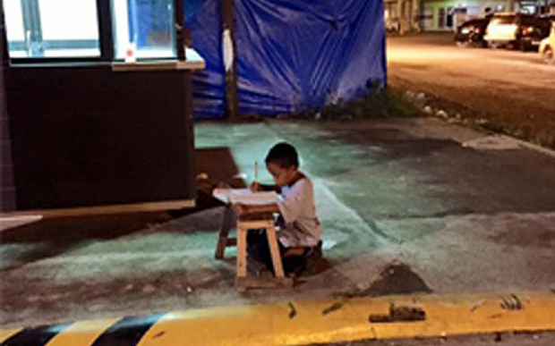 thegroovini's tweet photo. Daniel Cabrera, 9, is homeless.  He uses the light from a McDonald's to do his homework. No excuses.
#Manila http://t.co/CeMlHxnaZt