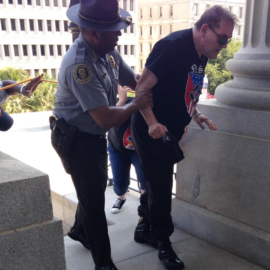Viral Photo Shows Black Police Officer Helping White Supremacist At Ku Klux Klan Rally CKOLgKIWUAAAxGI