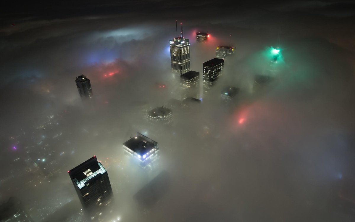 Toronto skyline submerged in fog.