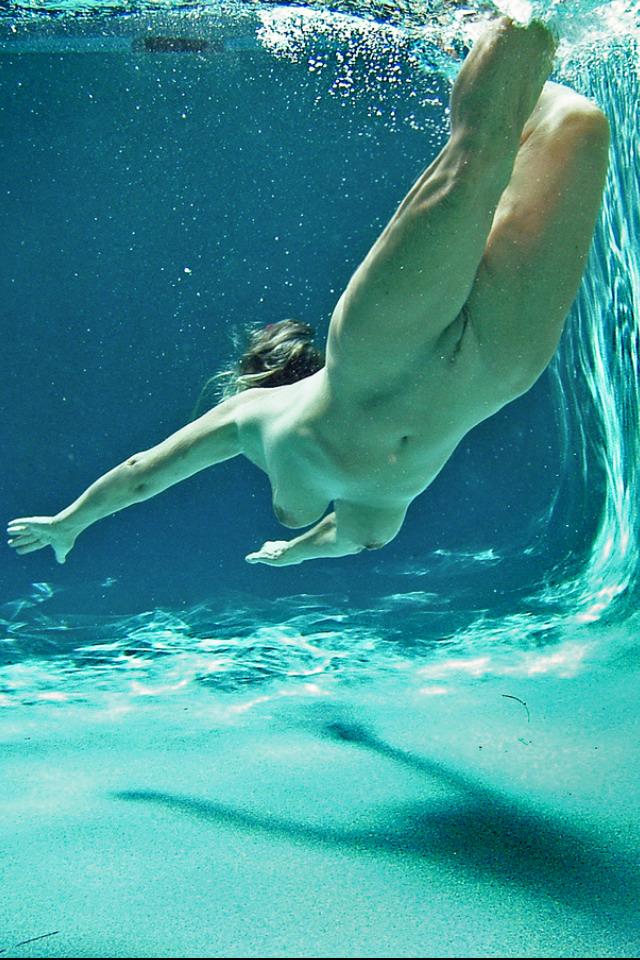 Julia is swimming underwater nude in the sea