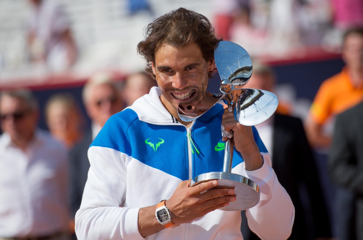Rafaholics's tweet photo. Rafa #Nadal biting his #Hamburg2015 trophy (AP) HQ: http://t.co/AIZdcwLSVZ http://t.co/yDG3q6K1if http://t.co/rJzbn7jFhX