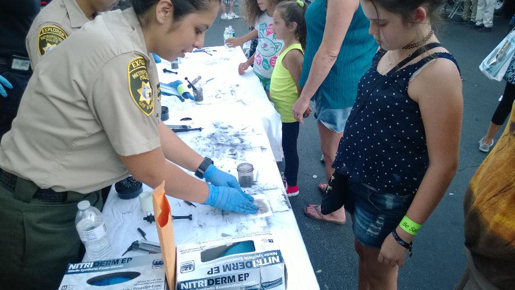 LVMPD's tweet image. Kids are learning about fingerprinting from our #LVMPDExplorers at Town Square tonight #NNO #NNO2015 @OfficialNNO