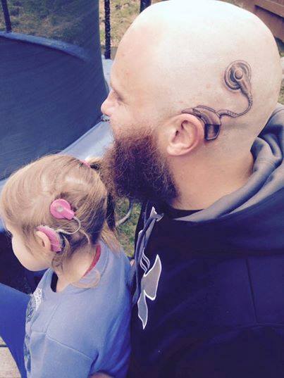 Charlotte Campbell age 6 with her dad Alistair who had a cochlear implant tattooed on his head to support Charlotte who is deaf. Photo / Dean Purcell, NZ Herald