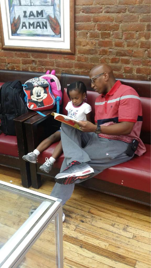 A father reading No David with his daughter at Levels Barbershop on 125th Street in Harlem #ReadEarlyandOften