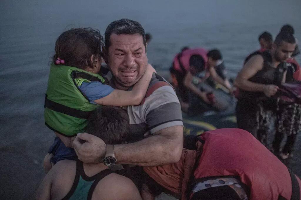 Salvar a tus hijos no puede ser ilegal. Sirios tocando tierra griega. Foto de Daniel Etter.
