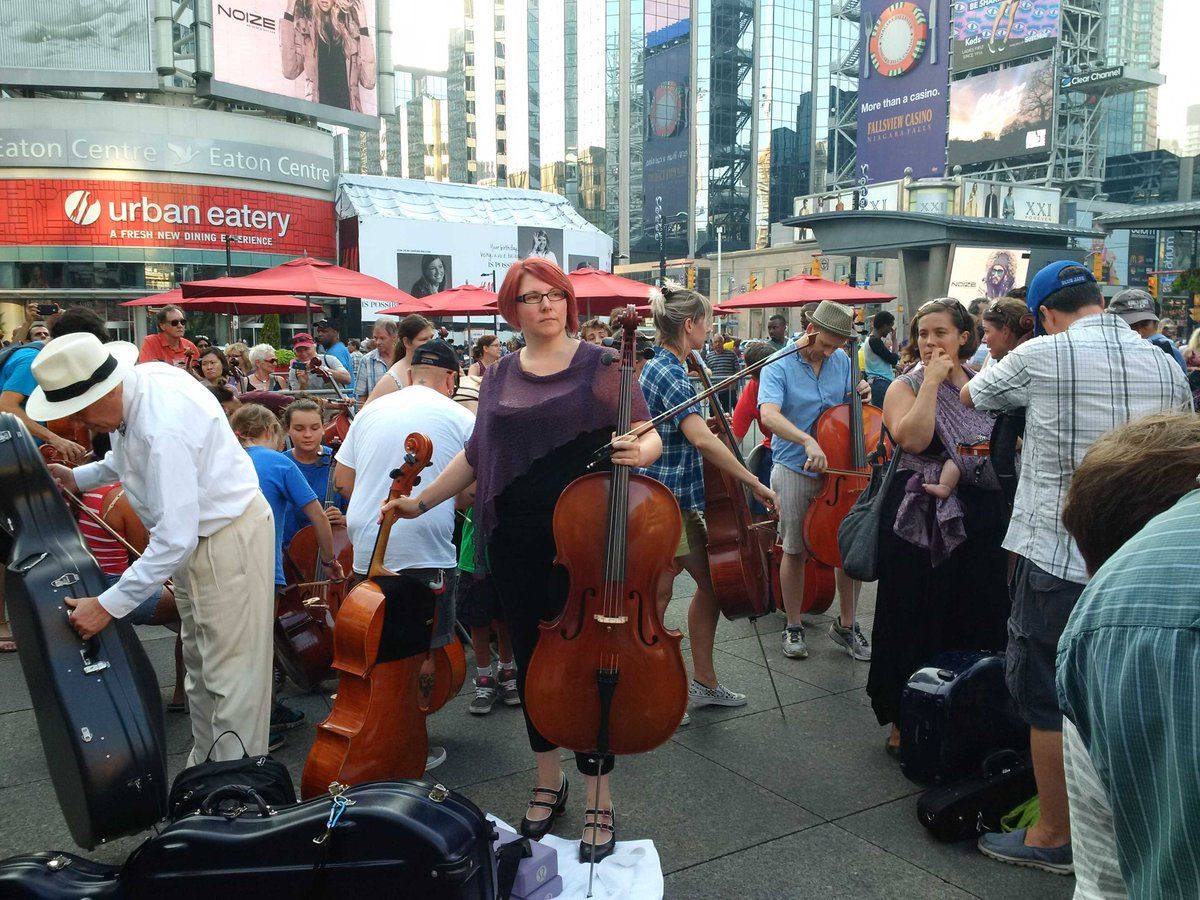 SEEChangemag's tweet photo. And the #1000strings players converge upon #DundasSquare #Toronto for #JohnOswald's "Spectre" #worldpremiere http://t.co/L0ZkXfSJNR