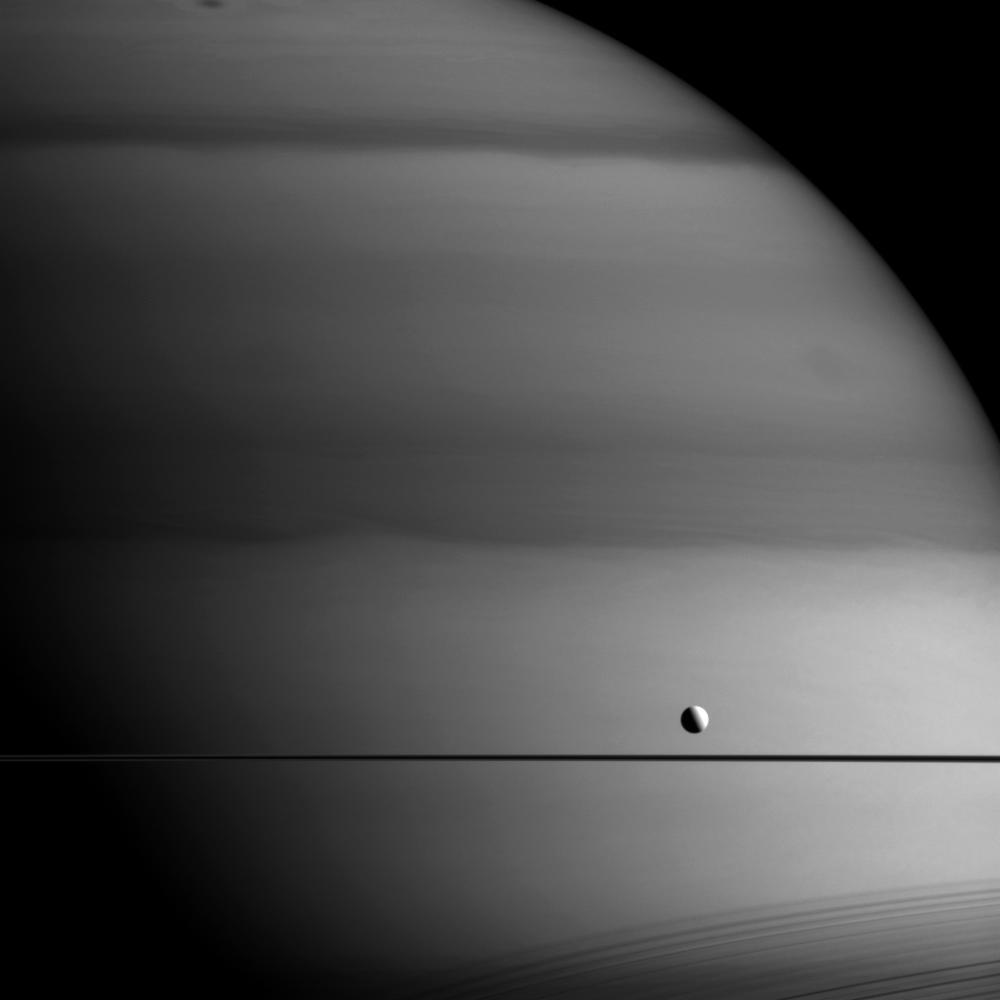 NASA's tweet photo. Saturn looks painted with a dark brush, but Dione looks untouched. Why? More: http://t.co/DI4GsTwx7j @CassiniSaturn http://t.co/vFDsI3ltEr