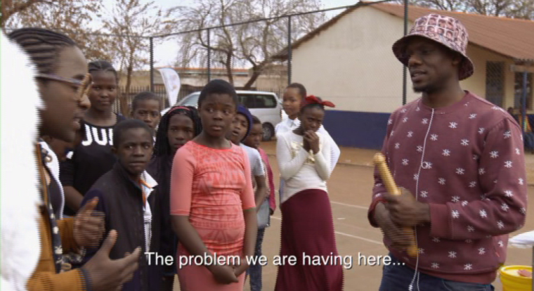 RealityCheck_SA's tweet photo. .@slikouron is in the house y'all. Watch him show young kids how to use a condom. #SlikourSOS http://t.co/OgwuapJL04