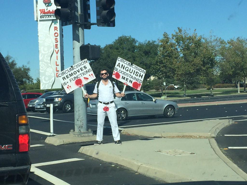 yggdrasil13751's tweet image. I've never seen a person protesting male circumcision before - dramatic signage/message.