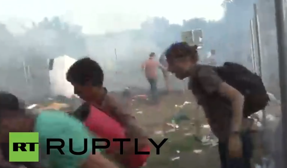 RT_com's tweet photo. WATCH LIVE: Hungarian police deploy tear gas to disperse refugees http://t.co/KkEJHg0oyq http://t.co/TSFsBdOvtD