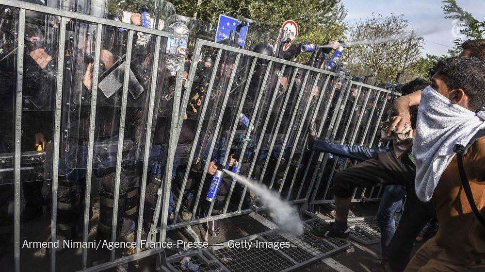 nytimes's tweet image. Hungarian police officers moved against hundreds of migrants at the border with Serbia  nyti.ms/1QGmX4n
